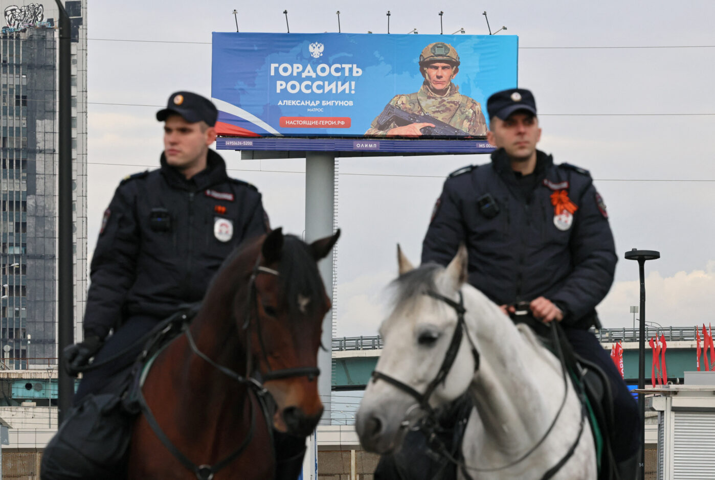 Конная полиция патрулирует улицу возле баннера с&nbsp;рекламой службы по&nbsp;контракту в&nbsp;Москве